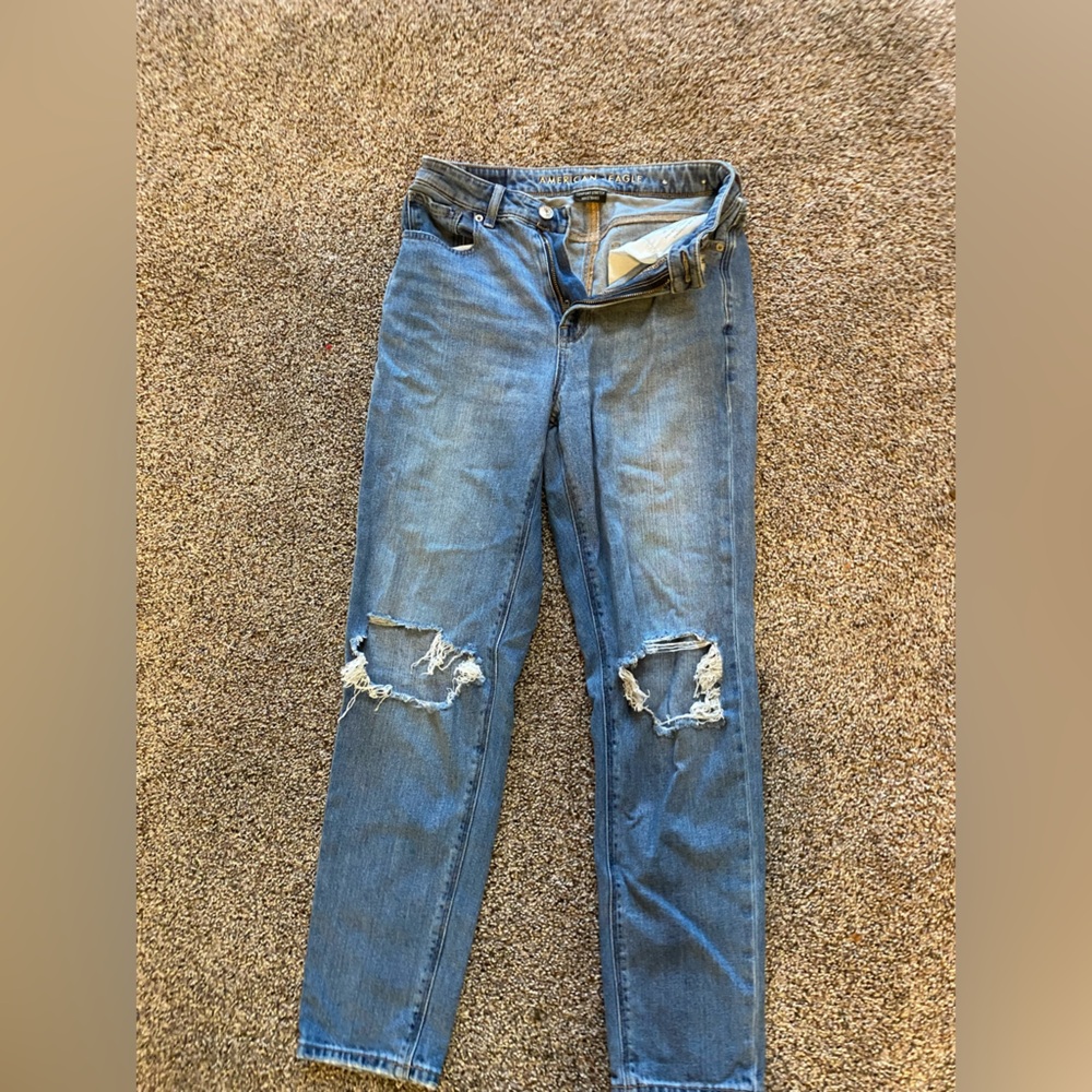 Medium dark high rise mom jeans with holes on the knees.